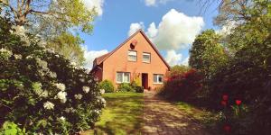 a red house with a pathway leading up to it at Ferienwohnung Schwantje in Aurich