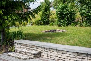 a brick wall in a yard with a fire pit at Agroturystyka Skalny Widok in Hucisko