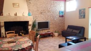 een woonkamer met een tafel en een open haard bij Gîte MarieJo in Villandraut