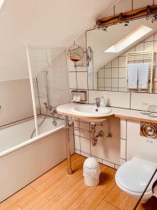 ein Badezimmer mit einem Waschbecken, einer Badewanne und einem WC in der Unterkunft Landhaus Kürrenberg in Mayen