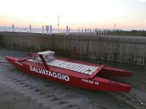 a red boat sitting on the sand at the beach at Il Miraggio in Fregene