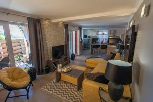 a living room with a yellow couch and a living room with a kitchen at Apartment Simon Says in Cres
