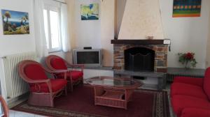 uma sala de estar com lareira e cadeiras vermelhas em Panorama sul lago em Porto Valtravaglia