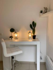 een wit bureau met kaarsen en planten erop bij CHARMANT T2 PROCHE CENTRE VILLE PLAGE JARDIN DIOR 50 m2 in Granville