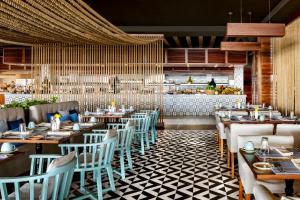 un restaurant avec des tables et des chaises en bois et un comptoir dans l'établissement Grand Velas Los Cabos Luxury All Inclusive, à Cabo San Lucas