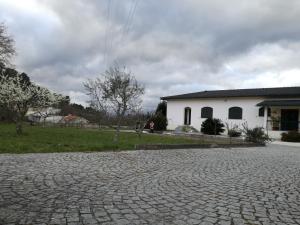 uma estrada de tijolos em frente a um edifício branco em Casa dos Laços em Viseu