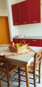a kitchen table with a basket of fruit on it at Ladybug Apartment in Poggibonsi