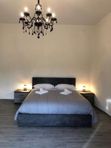 Un dormitorio con una cama grande y una lámpara de araña. en caolzio39 en CastellʼArquato