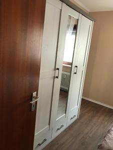 a white cabinet with a mirror next to a door at Central-Apartment-Adria in Saarbrücken
