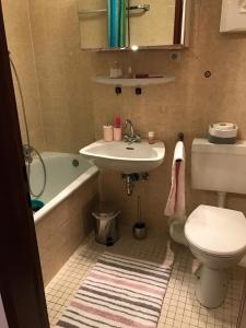 a bathroom with a sink and a toilet and a tub at Central-Apartment-Adria in Saarbrücken