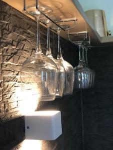 quatro copos de vinho pendurados numa prateleira na casa de banho em caolzio39 em CastellʼArquato