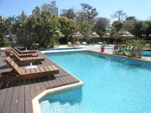 a large swimming pool with chairs and a wooden deck at La Foret in Punta del Este