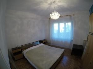 Schlafzimmer mit einem Bett und einem Kronleuchter in der Unterkunft Apartment Mrak in Lovran