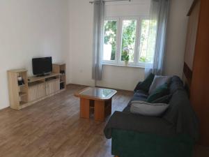 ein Wohnzimmer mit einem Sofa und einem Couchtisch in der Unterkunft Apartment Mrak in Lovran