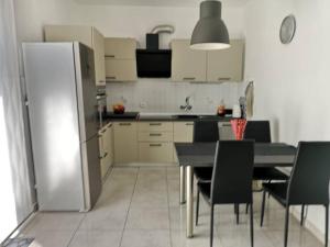 eine Küche mit einem Kühlschrank sowie einem Tisch und Stühlen in der Unterkunft Apartment Mrak in Lovran
