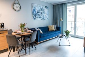 ein Wohnzimmer mit einem blauen Sofa und einem Tisch in der Unterkunft Augustiańska in Krakau