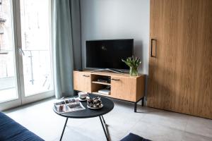 uma sala de estar com uma televisão e uma mesa de centro em Augustiańska em Cracóvia