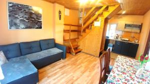 salon z niebieską kanapą i schodami w obiekcie Domek "IGOR" nad Jeziorem Żywieckim w Zarzeczu w mieście Zarzecze