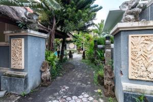 a path in front of a house with statues at Eddys Cottages & Villa in Legian