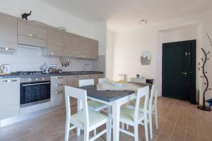 a kitchen with a table and chairs and a black door at Casa Sterinella in Follo Alto
