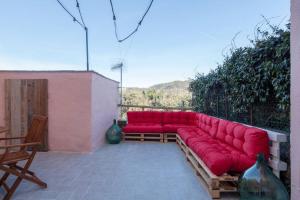 un sofá rojo sentado en la parte superior de un patio en Casa Sterinella, en Follo Alto