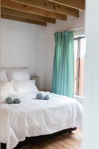 a white bed with blue towels on top of it at Sedgefield Beach House/Sedgefield Strandhaus in Sedgefield