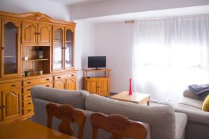 a living room with a couch and a tv at APARTAMENTO LOS NARCISOS in Chulilla