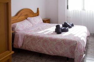 a bed with shoes sitting on top of it at APARTAMENTO LOS NARCISOS in Chulilla