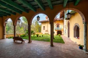 a courtyard with arches and a bench in front of a house at Castello di Montonate in Mornago