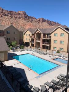 une grande piscine avec des chaises et un bâtiment dans l'établissement Moab Redcliff Condos, à Moab