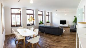 ein Wohnzimmer mit einem Sofa, einem Tisch und Stühlen in der Unterkunft DD Apartments in Dresden