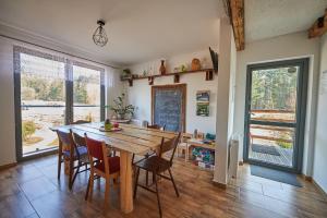 a dining room with a wooden table and chairs at Dolidkowo Slow Camp in Gwieździn