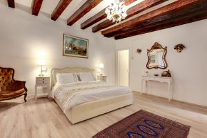 Habitación blanca con cama y lámpara de araña. en Ca' Invidia, en Venecia