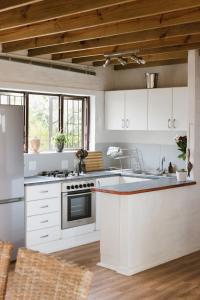 a kitchen with white cabinets and a stove top oven at Sedgefield Beach House/Sedgefield Strandhaus in Sedgefield