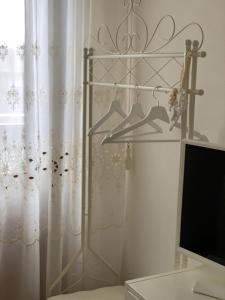 Una habitación con un estante con un televisor y una cortina. en Zá ‘Ntunietta, en Portopalo di Capo Passero