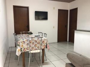 a dining room with a table with chairs and a tv at Jucelio João Inácio in Governador Celso Ramos