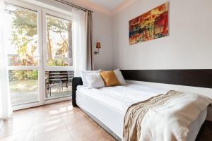 łóżko w pokoju z dużym oknem w obiekcie Pelikan Resort Dźwirzyno - Domki przy plaży w Dźwirzynie