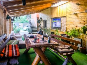 a patio with a wooden table and chairs in a room at Casa de vacanta Jeny in Novaci-Străini