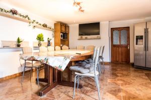 a kitchen and dining room with a wooden table and chairs at Casa de vacanta Jeny in Novaci-Străini
