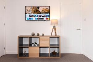 una mesa en una habitación con TV en la pared en No. 6 Apartment en Inverness