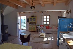 kuchnia i salon z kanapą i stołem w obiekcie Panorama, Balaton w mieście Dörgicse