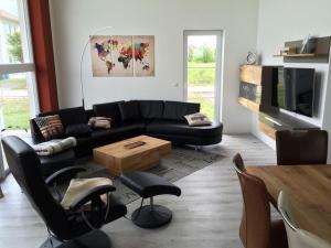 uma sala de estar com um sofá preto e uma mesa em Villa Ostseebrise em Trent