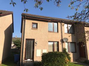 a brick house with a door and a window at No. 6 Apartment in Inverness