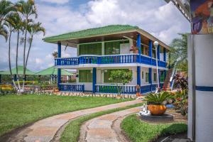 a blue and white house with a green roof at Finca Hotel La Molienda Quindiana in Montenegro