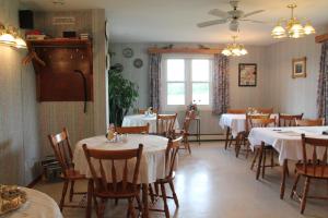 een eetkamer met tafels en stoelen en een raam bij Forest Haven Inn in Tatamagouche
