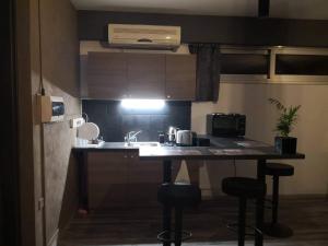 a small kitchen with a sink and two bar stools at The room in Larnaca