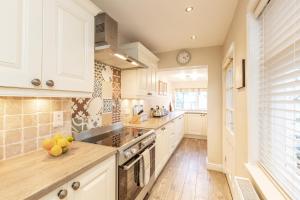 een keuken met witte kasten en een aanrechtblad bij Ravenscraig House in Staithes