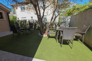 a patio with chairs and a table and a tree at Luxury Apartments Taša in Trebinje