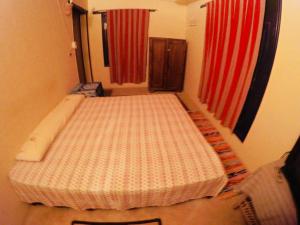 a bed in a room with two red curtains at villa tunis village in ‘Izbat an Nāmūs