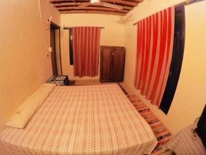 a bed in a room with red curtains at villa tunis village in ‘Izbat an Nāmūs
